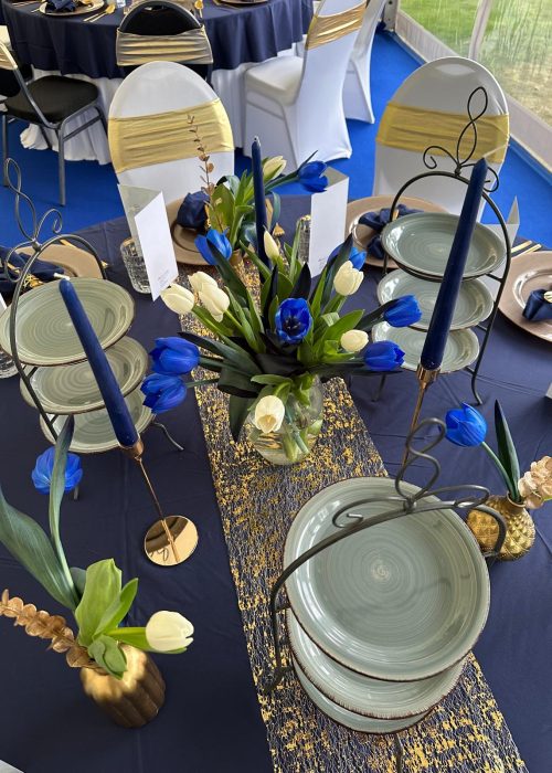 Elegante Tischdekoration mit blauen und weißen Tulpen sowie goldenen Kerzenständern
