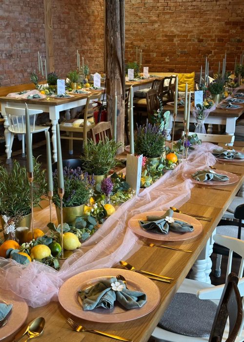 Festlich gedeckte Tafel im historischen Backstein-Loft mit Zitrusfrüchten und Kerzen